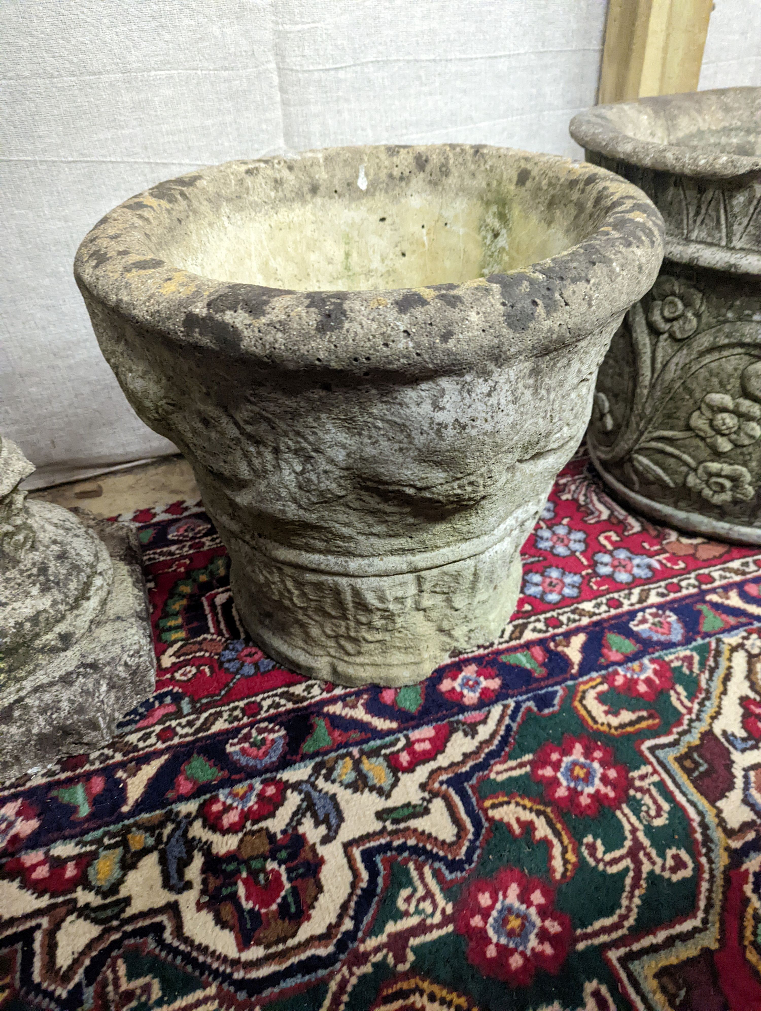 A reconstituted stone garden plinth, height 79cm, together with two circular garden planters, larger diameter 42cm